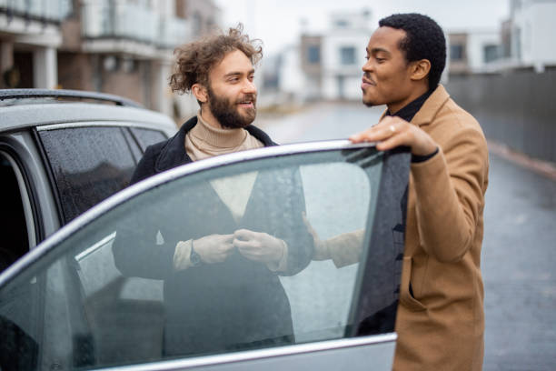 istock Two men flirting while standing near car on the street 1369073846