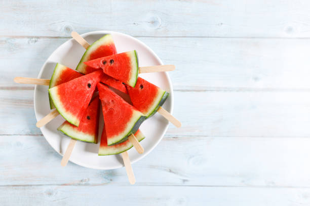 istock watermelon slices on light blue wooden background. 1369074070