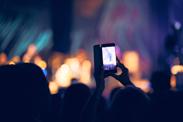 istock Person holding modern smartphone on a concert. 1369074072