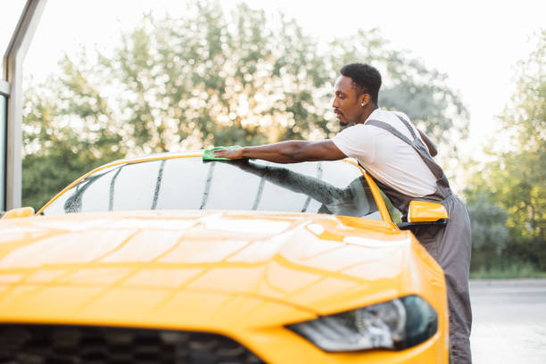 istock Handsome bearded young guy cleaning sport car windscreen 1369074212