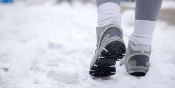 Hiking boot close-up, walking in snow. Close up of winter shoes