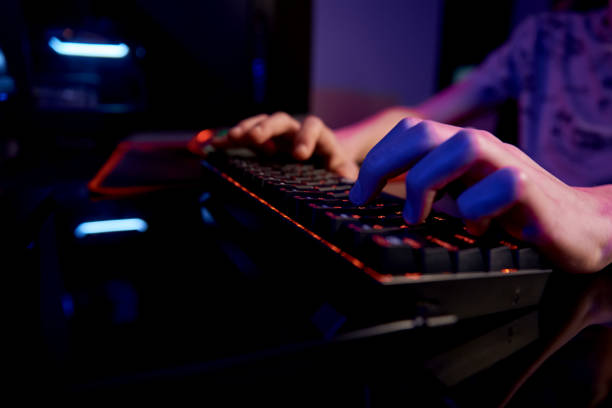 istock Gamer play computer game, use rgb neon colored keyboard 1369075776