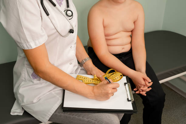 fat boy at a nutritionist appointment. boy consulting with doctor. - child obesity imagens e fotografias de stock