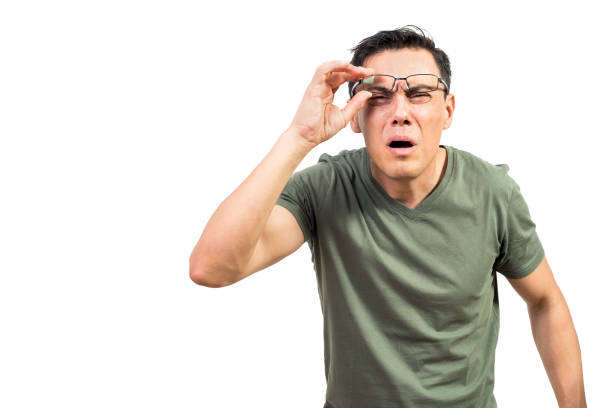 Blind male nerd looking at camera Smart man with bad eyesight lifting glasses and looking at camera while standing against white background eyesight stock pictures, royalty-free photos & images