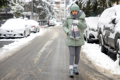 Young woman walking in the city on a snowy winter day