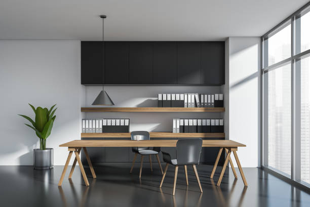 istock Dark office room interior with two armchairs, table, shelves 1369079261