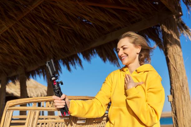 istock Middle aged woman on the beach talking online using smartphone. 1369079306