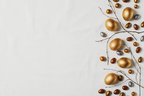 istock Happy easter concept flat lay with gold eggs and feather on white background 1369080410
