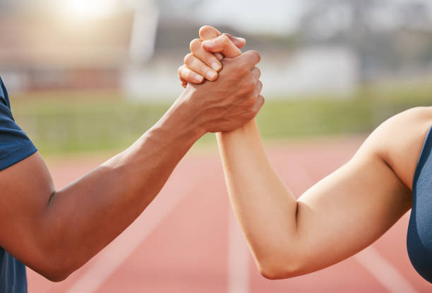 istock Cropped shot of two unrecognizable athletes shaking hands in solidarity while standing out on track 1369080558