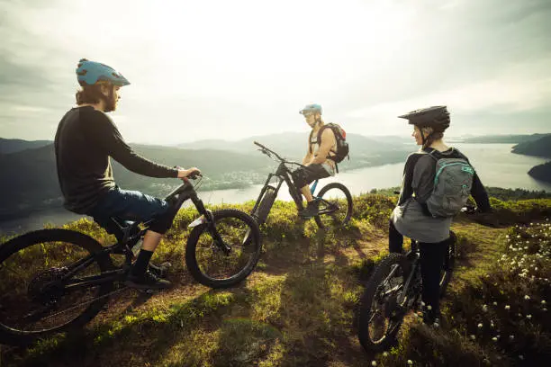 Group of friends mountainbike MTB riders: biking outdoor up mountain of Norway