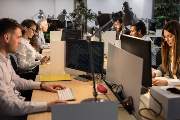 istock Large group of engineers working on computers at corporate office. 1369081697