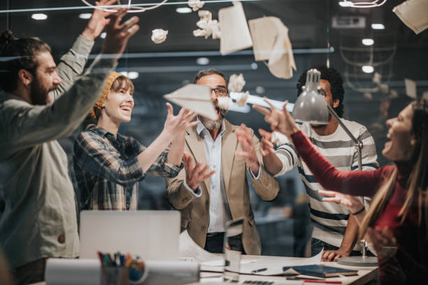 istock Joyful entrepreneurs having fun while throwing papers in the office. 1369081991