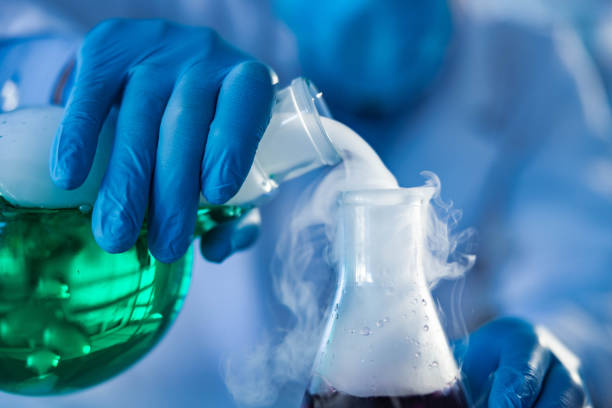 Close up of pouring smoke from laboratory flask. Close up of unrecognizable scientist pouring smoke from a beaker with green liquid in laboratory. beaker pour stock pictures, royalty-free photos & images