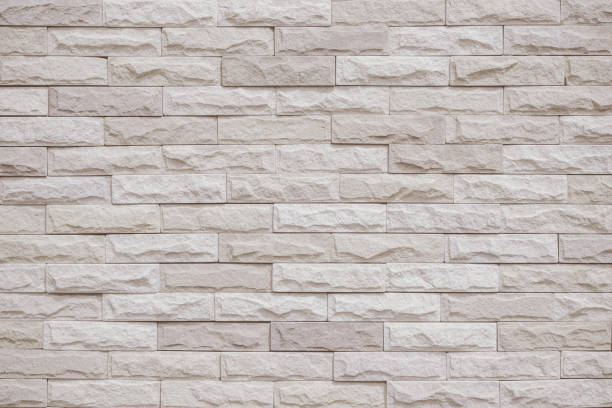 istock Cream and beige brick wall texture background. Brickwork and stonework flooring interior rock old pattern clean concrete grid uneven bricks office design. Background of old vintage brick wall backdrop 1369083336