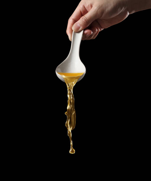 istock Spoon pouring noodle soup isolated on black background 1369083714