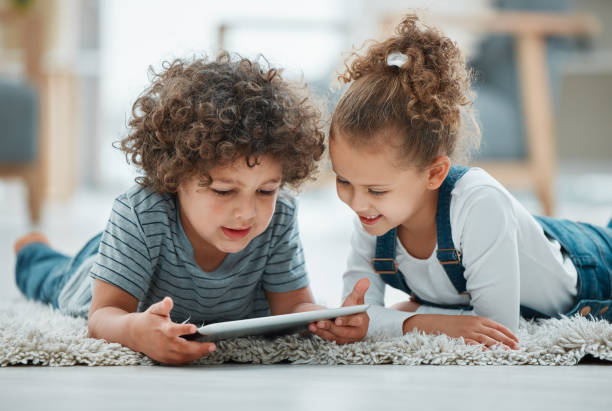 istock Shot of two siblings playing together with their digital tablet 1369085094