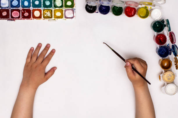istock Top view of children's hands while drawing gouache on paper. 1369085942