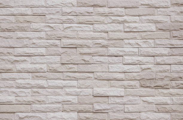 istock Cream and beige brick wall texture background. Brickwork and stonework flooring interior rock old pattern clean concrete grid uneven bricks office design. Background of old vintage brick wall backdrop 1369087050