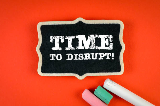 istock Time to Disrupt. Miniature chalk board on a red background 1369088389