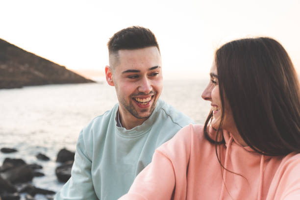 istock Young caucasian couple chatting at the sea side. 1369088581