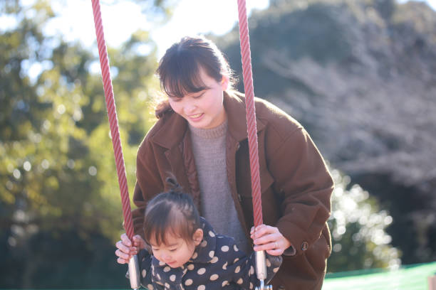 istock Parents and children playing on a swing 1369088780