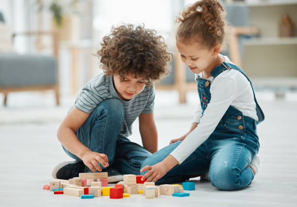 Shot of two siblings playing with building blocks