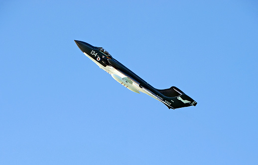 Sea Vixen in clear blue sky over Poole Bay, English Channel, England.  De Havilland Sea Vixen twin boom tail, twin engine jet airplane used by the British Fleet Air Arm of the Royal Navy for flight from aircraft carriers in air defence during the late twentieth century