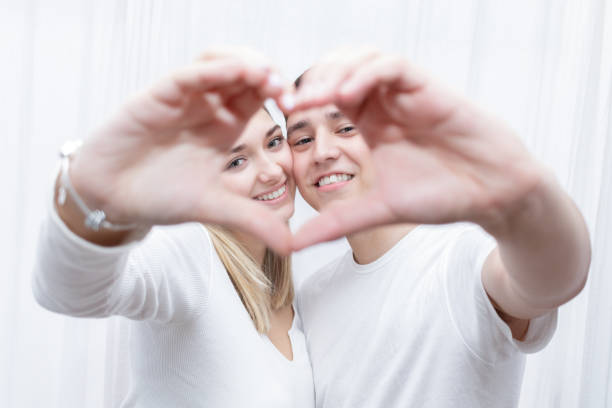istock Couple through a hand heart 1369093085