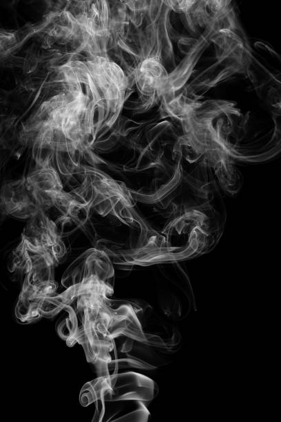 istock Clouds of curls of smoke on a black background. 1369093965