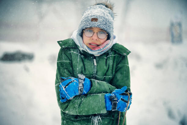 portrait d’un adolescent qui a très froid pendant le blizzard un jour d’hiver - grelotter photos et images de collection