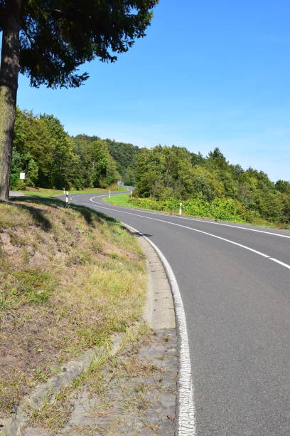 istock steep curvy road into open land, no barriers to the valley side 1369094527