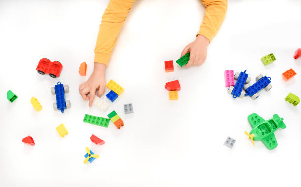 istock Close up kid boy hands playing with toys black on white background. 1369095834