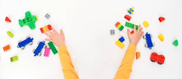 istock Close up kid boy hands playing with toys black on white background. 1369095850