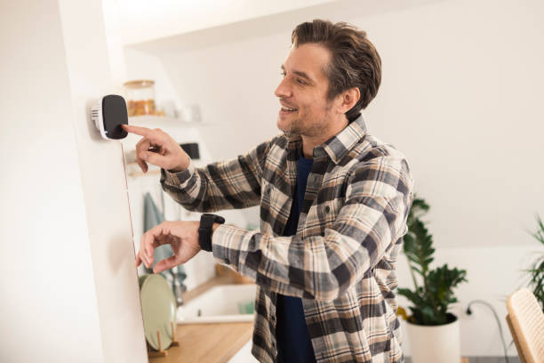 istock Happy man using a smartwatch to adjust his smart home devices 1369099798