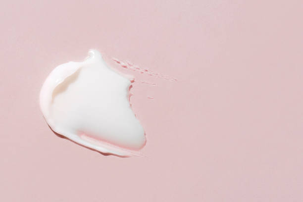 istock Smear of cream on a pink background. 1369100358