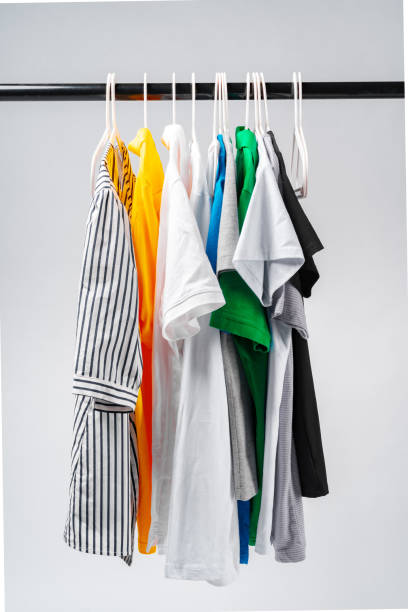 istock Clothes hang on clothing rack over white background. 1369100950
