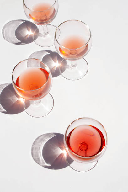 istock Glasses with rose wine and contrasting shadows on a white background 1369101005