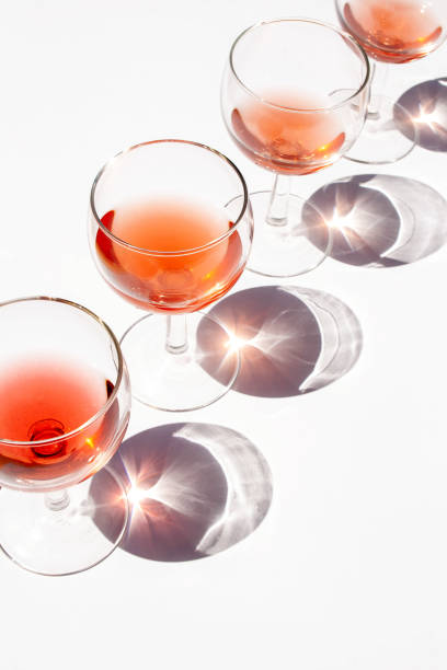 istock Wine glasses on white table with contrasting shadows 1369101031