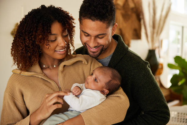 istock Smiling parents looking down at their baby boy in their arms 1369101059
