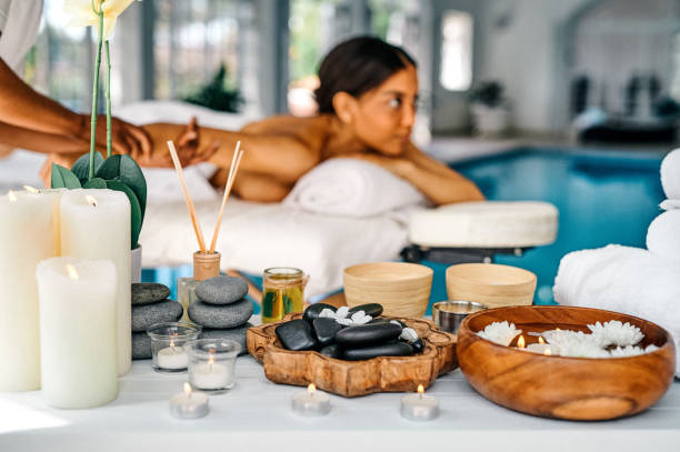 ベッドに横たわり、スパでマッサージを楽しんでいる若い女性のショット - massage therapist stone spa treatment working ストックフォトと画像