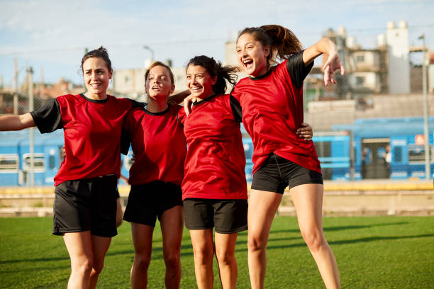 istock Female soccer team hugs after winning a match. 1369101304