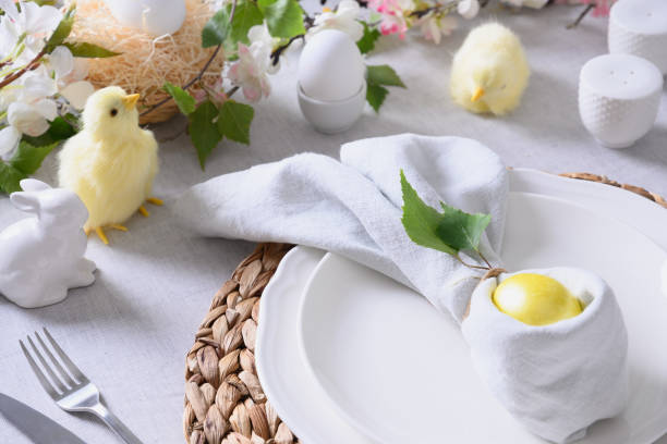 istock Easter table setting and dinner with yellow chick, festive decorations, fresh flowers and eggs. 1369101318