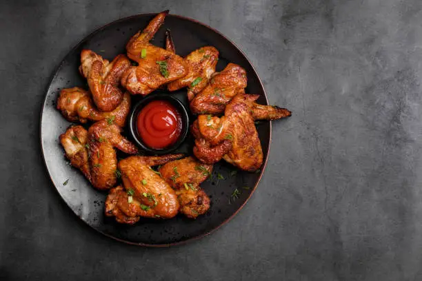 Photo of Plate of barbecue chicken wings. Top view.