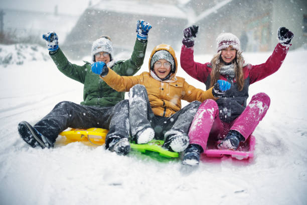 istock Portrait of three kids sledding during the blizzard 1369102515