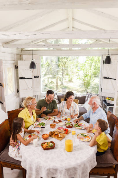 istock Happy extended family having a meal at dining table. 1369103007