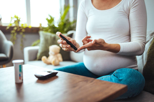 happy pregnant woman with glucometer checking blood sugar level at home. - diabetes blood sugar test insulin glucose imagens e fotografias de stock