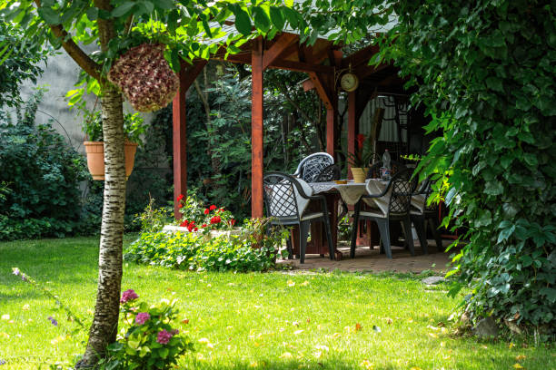 Courtyard with gazebo. Wooden gazebo with a clock in a shady courtyard garden on a bright summer day. gazebo stock pictures, royalty-free photos & images