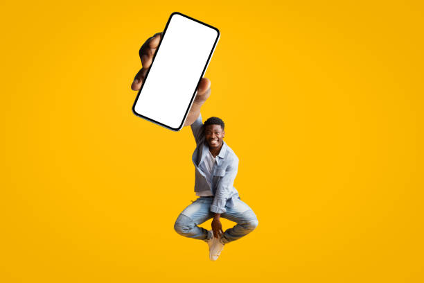 istock Positive stylish young black man showing newest mobile application 1369109875