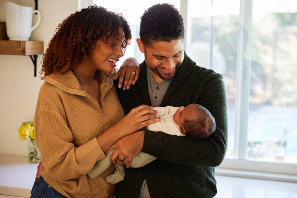 istock Parents standing in their kitchen and smiling down at their baby boy 1369109883