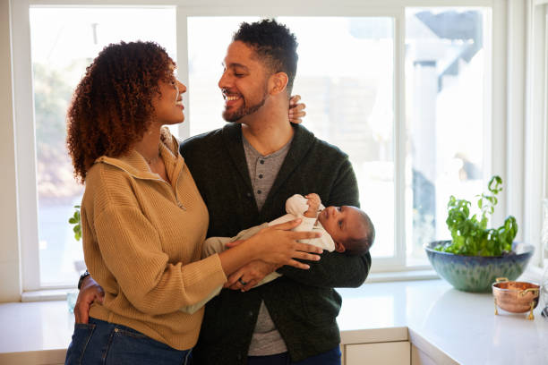 istock Affectionate couple smiling while standing with their baby boy in their kitchen 1369110951